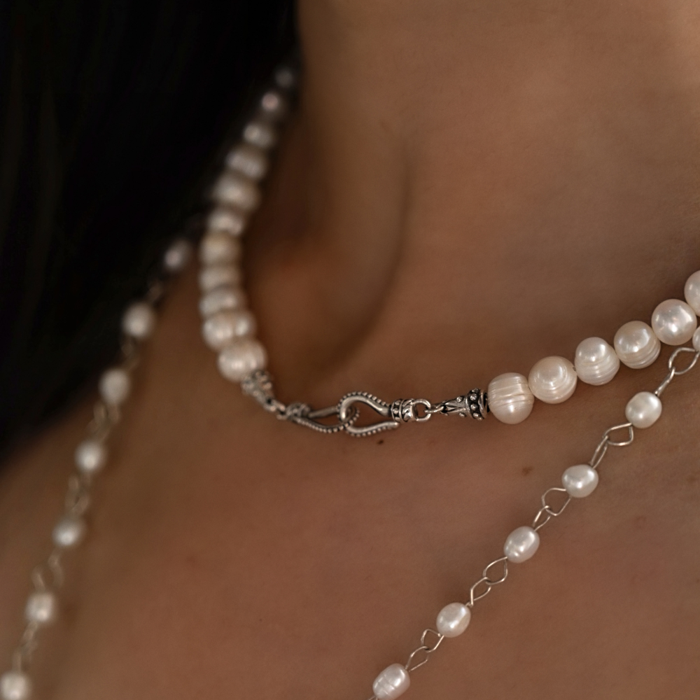 Pearl necklace with silver clasp on a person's neck