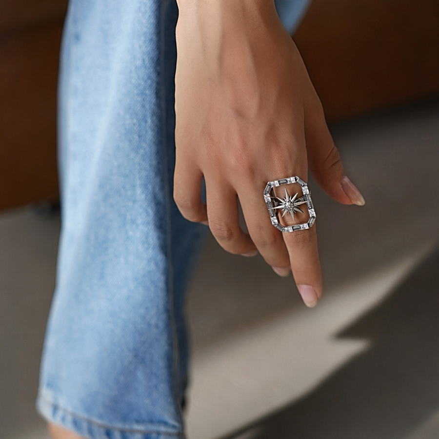 Hand wearing a star ring with a blurred background
