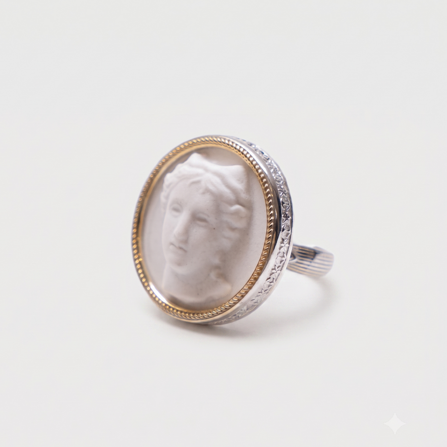 A silver ring featuring an oval bezel-set white carved classical bust, bordered by a gold-toned inner ring, on a clean white background.