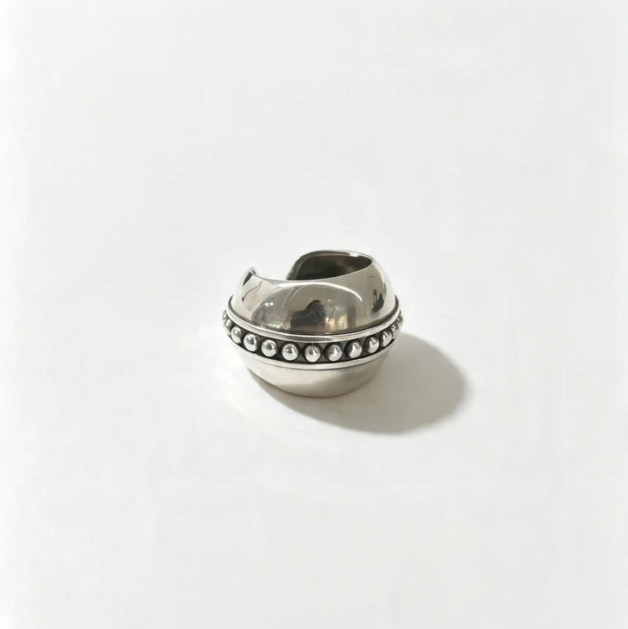 A polished silver ring with a decorative row of small clear stones, photographed on a clean white background.