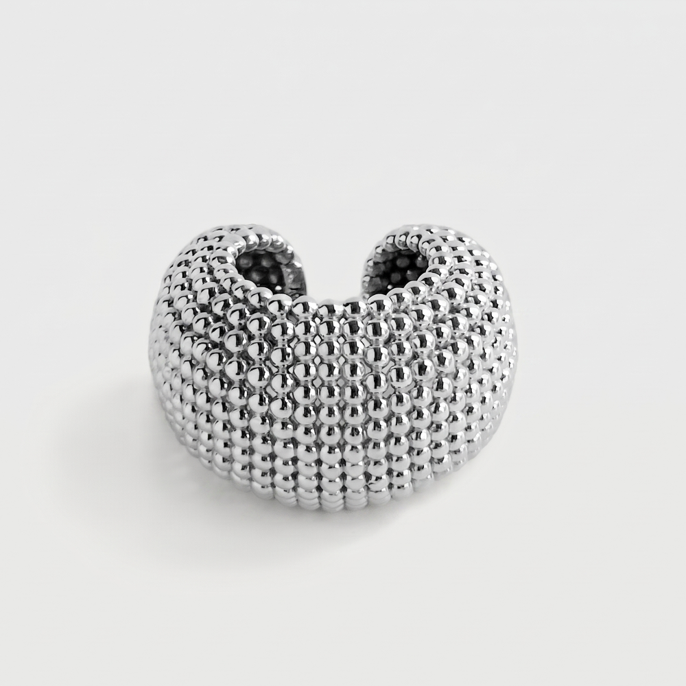 A textured silver ring with a honeycomb or beaded pattern, shown on a light gray background.