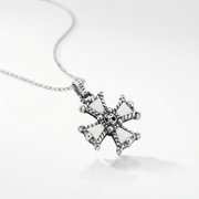 A silver cross pendant necklace with white enamel inlays and a detailed skull motif at the center, shown on a clean white background.