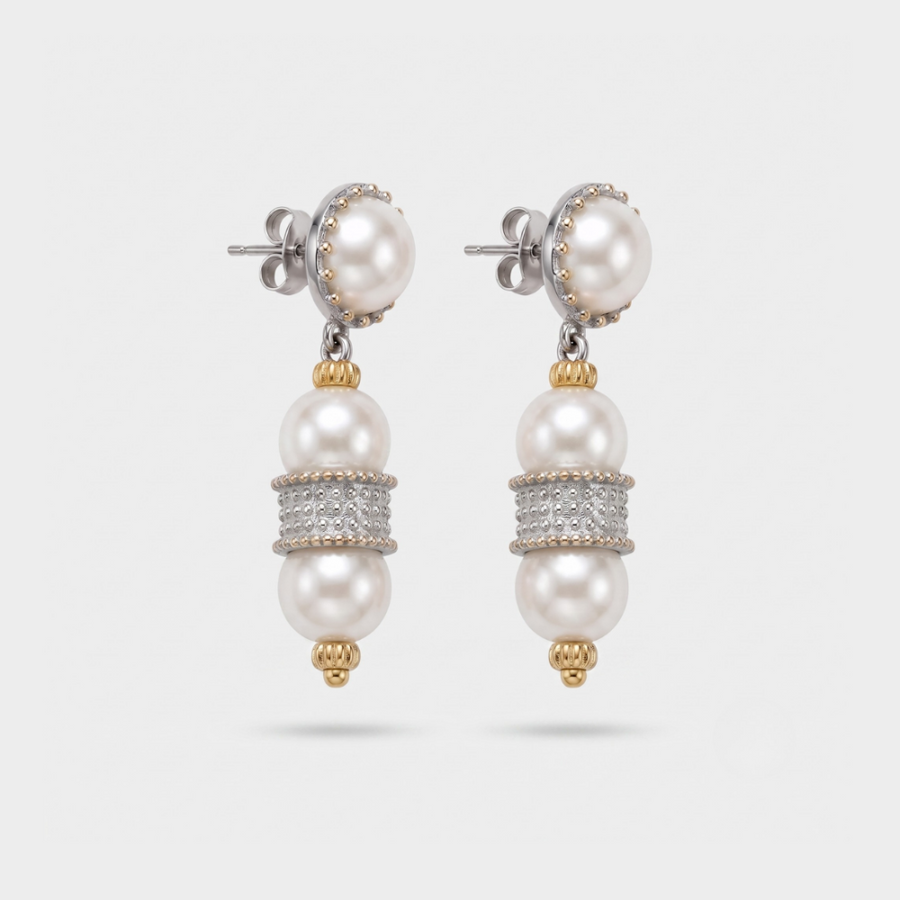 A pair of silver and gold drop earrings featuring white freshwater pearls, with a central band of pavé-set clear stones, shown on a light gray background.