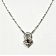 A silver-toned chain necklace with a geometric pendant featuring a central dark brown marquise-cut stone surrounded by small clear stones, set against a plain white background.