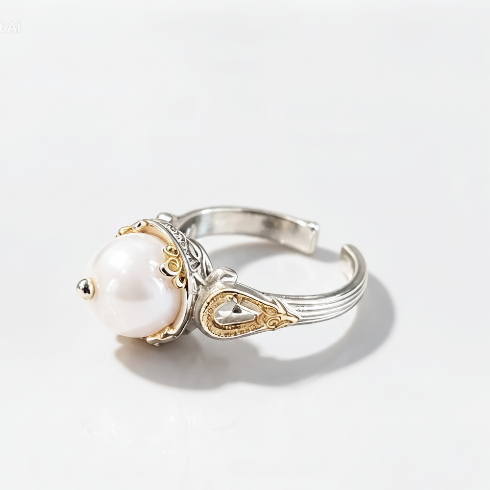 A silver and gold adjustable ring featuring a large white pearl, photographed on a clean white background with a soft shadow.