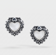 A pair of silver heart-shaped earrings with ornate scrollwork borders and white mother-of-pearl centers, shown on a light gray background.