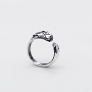 A silver snake ring with a textured, raised head and an open adjustable band, shown on a light gray background.