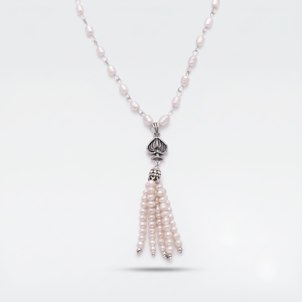 A silver-toned necklace featuring a beaded chain with small pale pink pearls, a silver lotus-shaped pendant, and a dangling tassel made of multiple strands of pale pink pearls, shown on a light gray background.