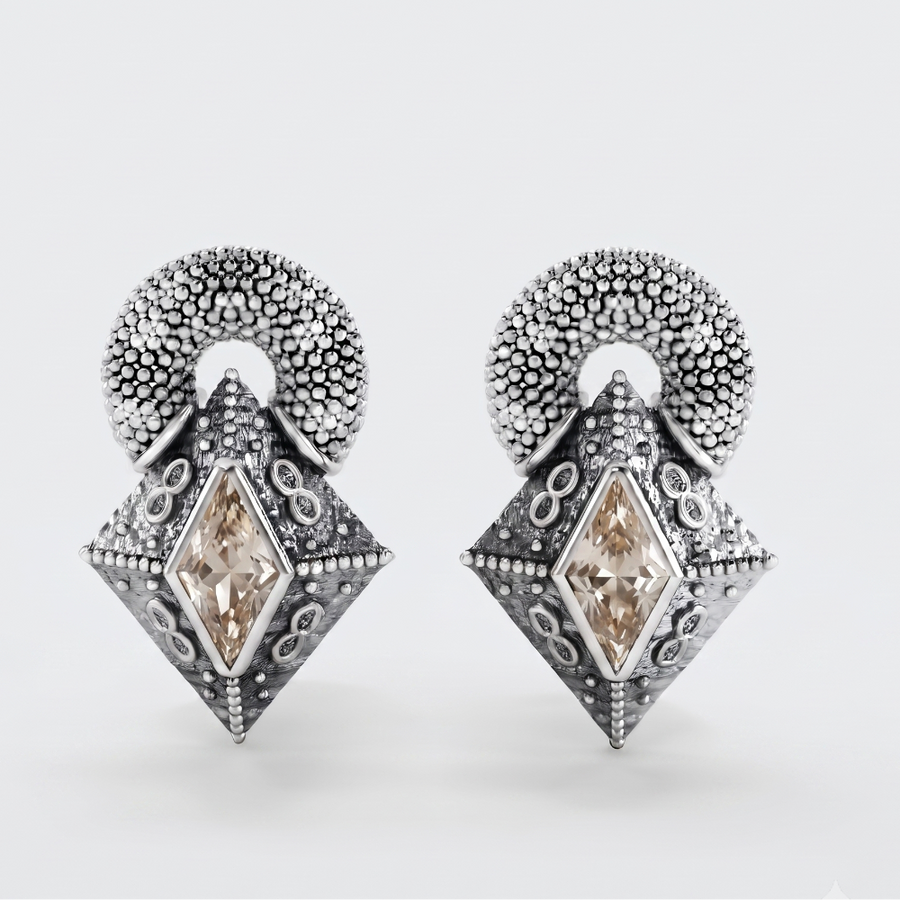 A pair of silver-toned drop earrings with textured circular tops and diamond-shaped pendants featuring marquise-cut champagne-colored stones, shown on a light gray background.