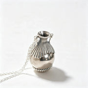 A silver urn-shaped pendant necklace with a detailed ribbed neck and a delicate chain, photographed on a clean white background.