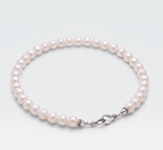 A strand of lustrous white freshwater pearls arranged in a circle with a silver-toned knotted clasp, photographed on a clean light gray background.